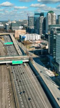 Atlanta, Georgia, ABD - 02 Ocak 2024: Otoyol şehir merkezinde arabalarla dolu. Yol üstgeçitleri ve yeşil arka planda işaretler. Dikey video.