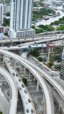 Miami, Florida, ABD - 05 Ocak 2024: Şehir merkezindeki köprülerle ve üstgeçitlerle çok katlı kavşak. Araba trafiği. Dikey video.