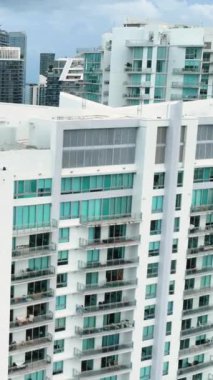 Miami, Florida, ABD - 05 Ocak 2024: çok katlı beyaz gökdelenler. Brickell şehir merkezinin havadan görüntüsü. Dikey video.