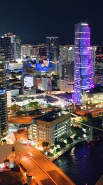 Miami, Florida, ABD - 05 Ocak 2024 Akşam Işıkları. Miami şehir merkezinde, parlayan gökdelenleri, caddeleri var. Miami Nehri. Dikey video.