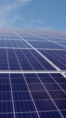 Güneş panelleri mavi gökyüzüne ve bulutlara karşı alternatif enerji. Dikey video.