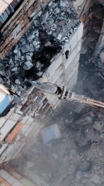 İnşaat alanındaki Buldozer Mekanik Kolu 'nu kullanarak Eski Beton Binası' nı yok etmek. Hava görüntüsü. Dikey video.