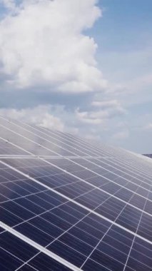 Modern fotovoltaik güneş pillerinin yakın çekimi. Sahaya sürdürülebilir enerji güneş panelleri yerleştirildi. Bulutlu gökyüzü. Dikey video.
