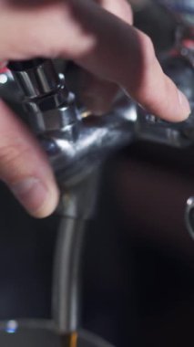 Barmenin elini kapat ve bardaki bardağa bira dök. Köpüklü bira dökme işlemi. Dikey video.