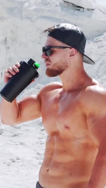 Ένας Δυνατός Αθλητής Χωρίς Πουκάμισο Πίνει Νερό Από Ένα Μπουκάλι — Αρχείο Βίντεο