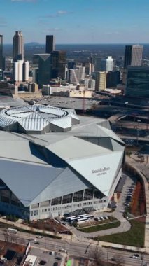 Atlanta, Georgia, ABD - 02 Ocak 2024: Mercedes-Benz Stadyumu 'nun havadan görünüşü. Güneşli kış gününde gökdelenleri olan şehir merkezi. Dikey video.