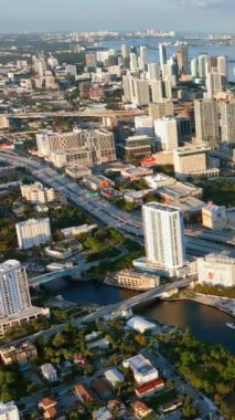 Miami, Florida, ABD - 05 Ocak 2024 Miami şehir merkezinin akşam manzarası. Evlere güneş ışığı. Dikey video.