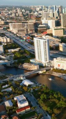 Miami, Florida, ABD - 05 Ocak 2024: Miami Nehri, şehir merkezinde tekne ve köprüler. Gün batımı. Dikey video.