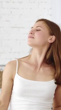 Mutfakta gülümseyen bir kız elinde portakal dilimi sunuyor. Dikey video.