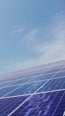 Çatıdaki evde geniş güneş panelleri var. Modern enerji santrali, yenilikçi yeşil enerji teknolojileri. Dikey video.