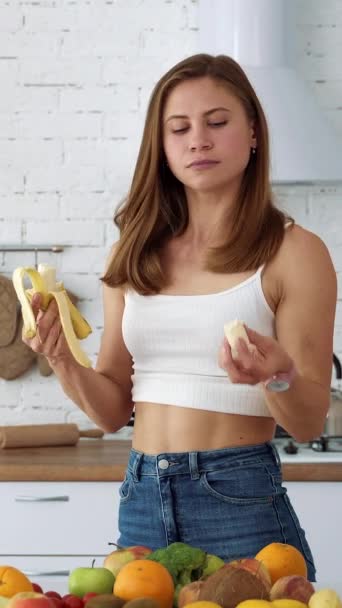 Vrolijk Meisje Eet Een Banaan Een Witte Keuken Met Een — Stockvideo