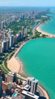 Chicago Oak Caddesi Plajı ve Lake Shore Yolu. Michigan Gölü kıyılarının havadan görünüşü. Dikey video.