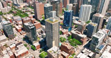 Chicago Nehri 'nin kuzeyinde. Uzun binaları ve yeşil ağaçları olan güneşli şehir sokakları. Araba trafiği..