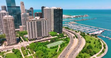 DuSable Limanı 'nda gökdelenleri ve yatları olan kıyı manzarası. Tenis kortu olan yeşil park. Chicago 'nun New East Side bölgesinde..