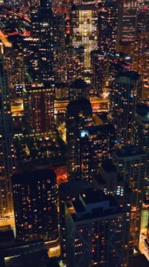 Chicago 'nun gece ışıkları. Işık saçan yüksek parlak gökdelenler. Trafikli gece sokakları. Hava görünümü.