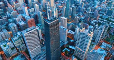 Chicago şehrinin aydınlatma ve sokak ışıklarıyla akşam manzarası. Gökdelenlerin ve çatıların yukarıdan görünüşü.