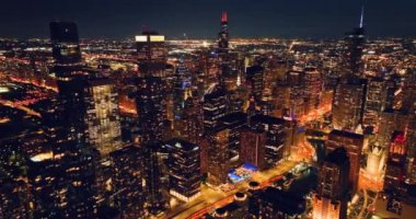 Chicago ve Riverwalk 'un gece görüş alanı oluşturuluyor. Gökdelen pencerelerindeki sarı parlak ışıkların ve gece sokak ışıklarının en üst görüntüsü.