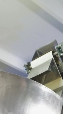 Atıştırmalık mısır çubuklarını taşımak ve üretmek için metal konteynerlerle taşıyıcı. Dikey video.