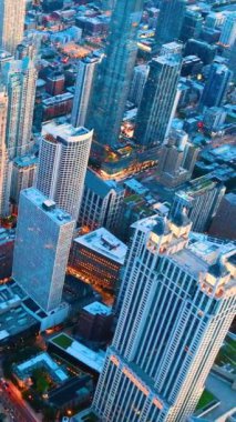 Chicago Metropolis gökdelenine karşı mavi binalar. İyi akşamlar şehir ışıkları. Hava görüntüsü. Dikey video.
