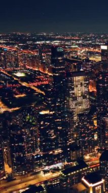 Chicago şehir merkezinde güzel bir akşam manzarası var. Aydınlatılmış hava manzaralı gece sokağı. Dikey video.