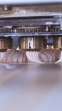 Sufle çıkarmak ve bükülmüş marşmelov oluşturmak için otomatik makine. Fabrikadaki nakliye hattı. Dikey video.