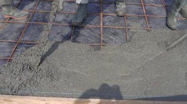 İnşaatçılar beton bir levhayı pompa kullanarak demir takviyesiyle dolduruyorlar. İnşaat alanı. Yakın plan..