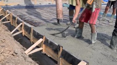 Çimento karışımı dökülüyor ve dolduruluyor. Evin temelinin inşaatı.