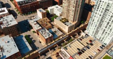 Chicago, Illinois, ABD - 01 Haziran 2024: Şehir merkezinde trenin bulunduğu çatıların, sokakların ve metro hattının havadan görünüşü.