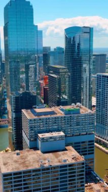 Chicago, Illinois, ABD - 01 Haziran 2024: Şikago 'da güneşli bir günde finans bölgesinde modern kule binaları veya gökdelenler. Dikey video.