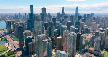 Nehir boyunca gökdelenlerle Chicago 'nun gökyüzü manzarası. Yeşil park alanı olan şehir merkezinde. Ufukta mavi gökyüzü olan şehrin manzarası..