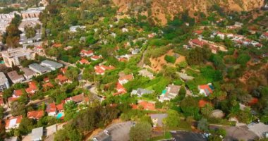 Kırmızı kiremit çatılı tek katlı evler. Los Angeles 'ın banliyölerindeki sokakların tepeden görünüşü. Yaz güneşli bir gün.