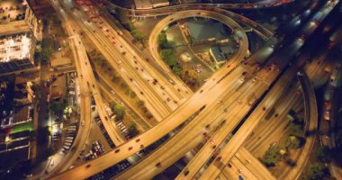 Çok katlı trafik kavşağının gece aydınlanması. Arka ışıklandırılmış yolların modern gelişimi ve Los Angeles 'taki mevcut yeni altyapı. Hava aracı bakış açısı.