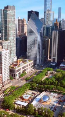Chicago göl kenarındaki güzel Milenyum Parkı manzarası. Yeşil bölgenin modern mimariyle birleşiminin çarpıcı görüntüsü. Hava görüntüsü. Dikey video.