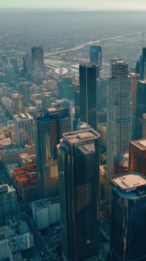 Los Angeles, CA, ABD - 15 Eylül 2024: Los Angeles şehir merkezinde yansıtıcı cam yüzeyli modern mimari sergilenmektedir. Dikey video.