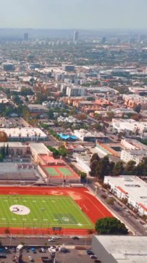 Los Angeles, CA, ABD - 15 Eylül 2024: Hollywood hava manzaralı ünlü bulvar. Hollywood Lisesi futbol sahası. Dikey video.