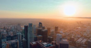 Los Angeles, CA, ABD - 15 Eylül 2024: günbatımında Los Angeles Panoraması. Şehrin iş merkezi. Güneş ışınlarında gökdelenler var. Hava görünümü.