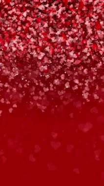 Düşen küçük kalplerin arkaplanı ve kırmızı renkte parçacıklar. Yazı için boş alanı olan döngülü romantik animasyon. Dikey video.