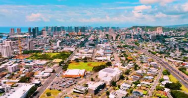 Güneşli bir günde, Moiliili bölgesindeki Honolulu şehrinin panoraması. Ulaşım araçları ve konut binaları olan sokaklar. Hava görünümü.