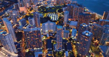 Oahu Waikiki Sahili ve okyanusuyla gece Honolulu şehir manzarası. Pencerelerinde ışıklandırma olan çok katlı otel binaları..
