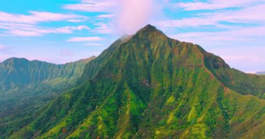 Oahu adasında yeşil sık ormanlarla kaplı dik yamaçları olan pitoresk volkanik dağ. Bulutlu mavi gökyüzü. Hawaii mi? Hava görünümü.