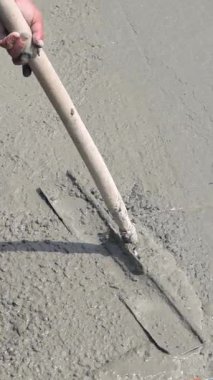 İnşaat alanında temel sıvı betonu dengeleme ayrıntıları. Elle beton seviyelendirme işi. Dikey video.