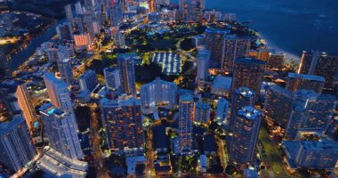 Alacakaranlık Hawaii 'de Honolulu silueti ve Waikiki plajı. Hava görüntüsü. Geceleri seçkin, çok katlı oteller. Parlak sokaklar.