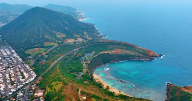 Körfez ve kumlu plajların yakınındaki okyanus kıyısındaki yerleşim alanlarının panoramik görüntüsü. Hawaii, Oahu 'daki Hanauma Körfezi' nin Hava Görüntüsü.