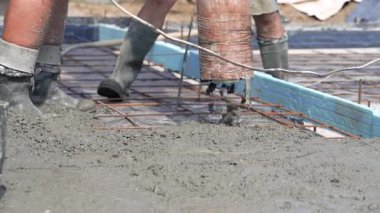 Demir bir ızgarayla güçlendirilmiş tek parça beton bir temel döşeme. Bir boruyla mekanize beton karışımı. Yakın plan..