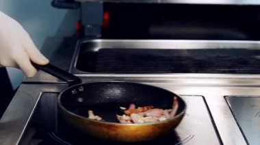 Fırında etli kızartma tavası. Profesyonel aşçı, restoranın mutfağında domuz pastırması kızartıyordu. Yakın plan..