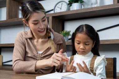 Güzel bir anne, güzel kızına evde ödev yapmayı öğretiyor. Konuşuyorlar ve gülüyorlar. Birlikte mutlu mesut.