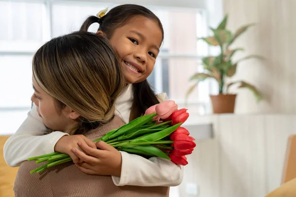 Прекрасная Дочь Обнимает Свою Мать Дарит Букет Цветов Тюльпанов Дома — стоковое фото
