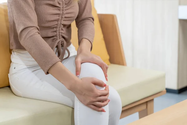 Asiatische Junge Frau Sitzt Auf Dem Sofa Und Spürt Knieschmerzen — Stockfoto