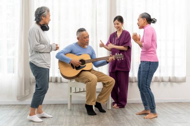 Asyalı son sınıf öğrencilerinin gitar çaldığı mutlu bir an ve huzurevinde birlikte şarkı söyleyip dans ettikleri bir kadın grubu.