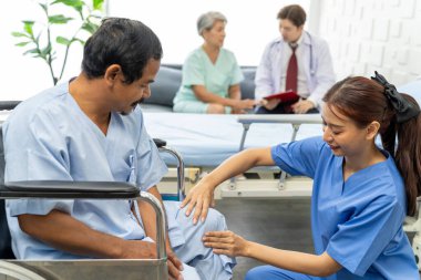 Genç kadın doktor, yaşlı hastanın dizine dokunuyor, kadın cerrah, hastanedeki ameliyattan sonra dizlerinin durumunu kontrol ediyor.